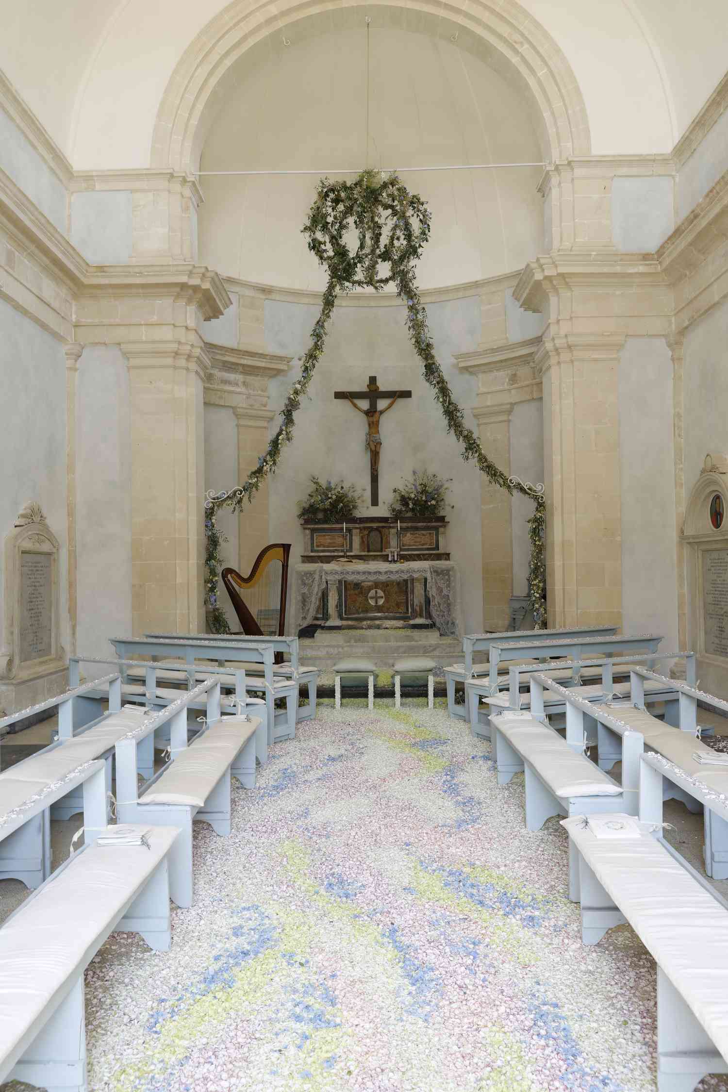 Church wedding aisle with painted aisle floors and cross and garland on back wall