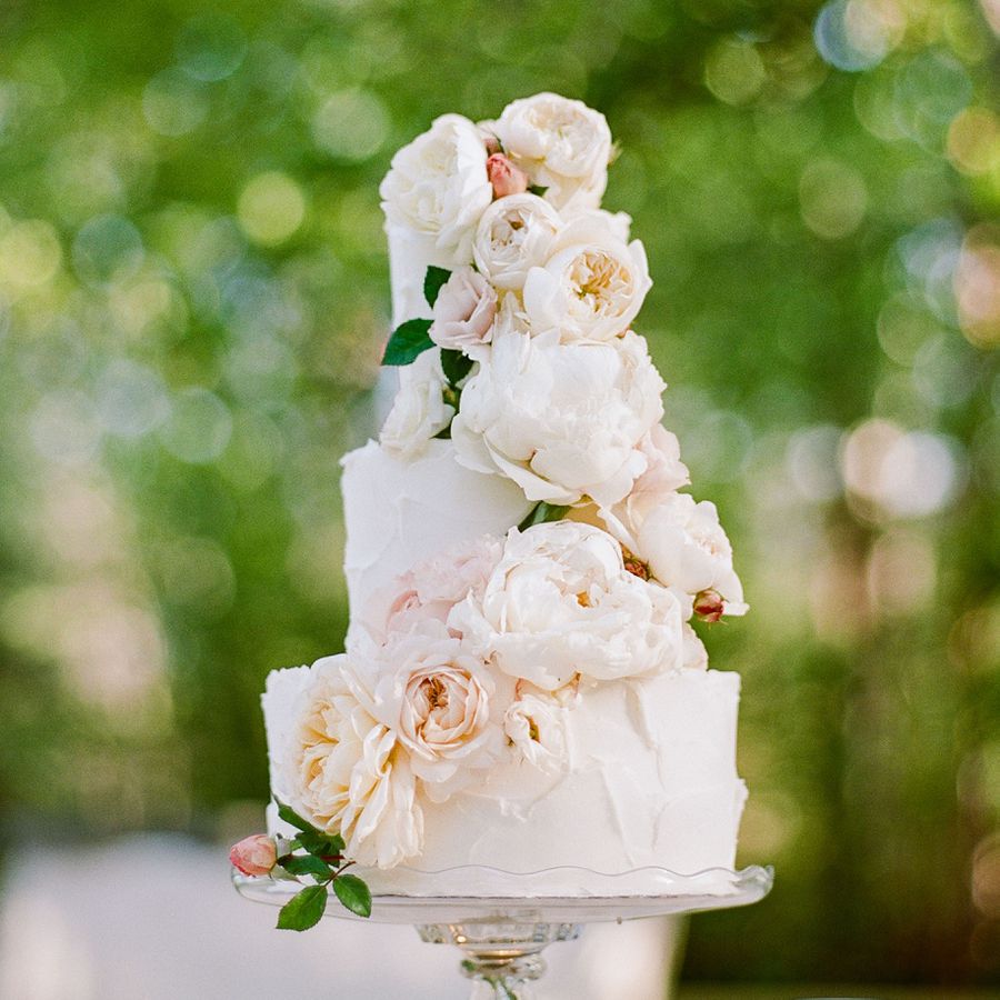A buttercream wedding cake with peonies and roses. 