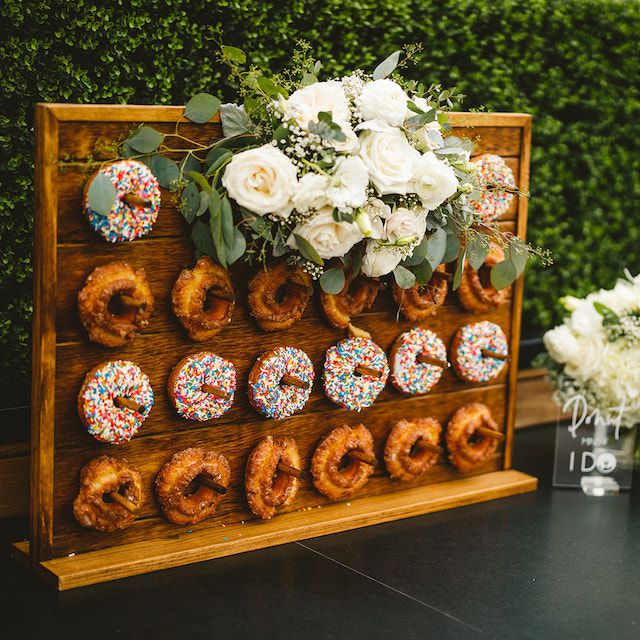 Small donut wall featuring white flowers for a small, intimate ceremony