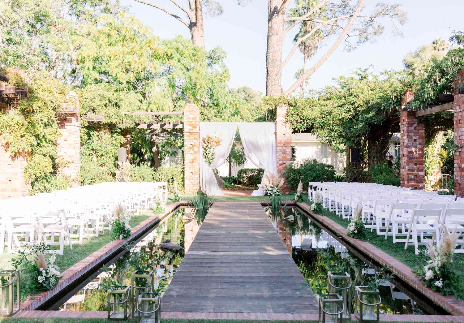 Ceremony with a boardwalk aisle crossing a garden pond