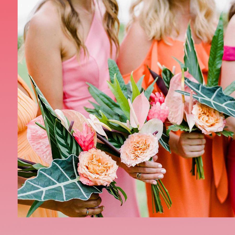 Bridesmaids holding bouquets with anthuriums, palm leaves, and pink peonies