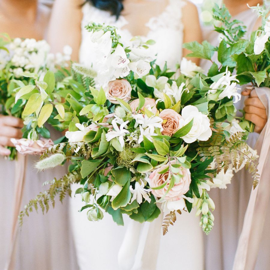 Bride and Bridesmaids Holding Spring Bouquets with Roses and Greenery