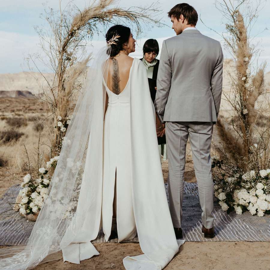 bride and groom at an altar in the desert