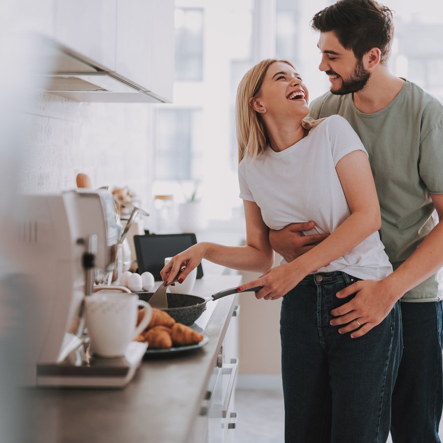 Smiling couple embraces in kitchen