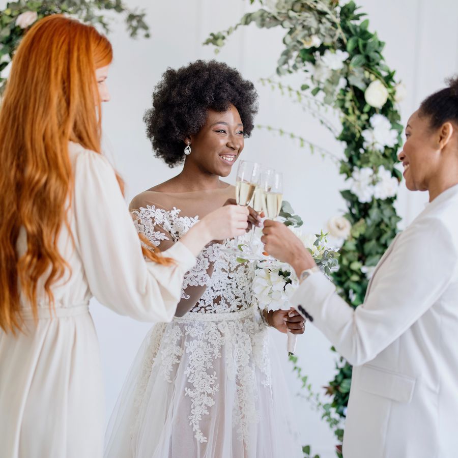 bride talking to guests wearing white at her wedding and doing a champagne toast