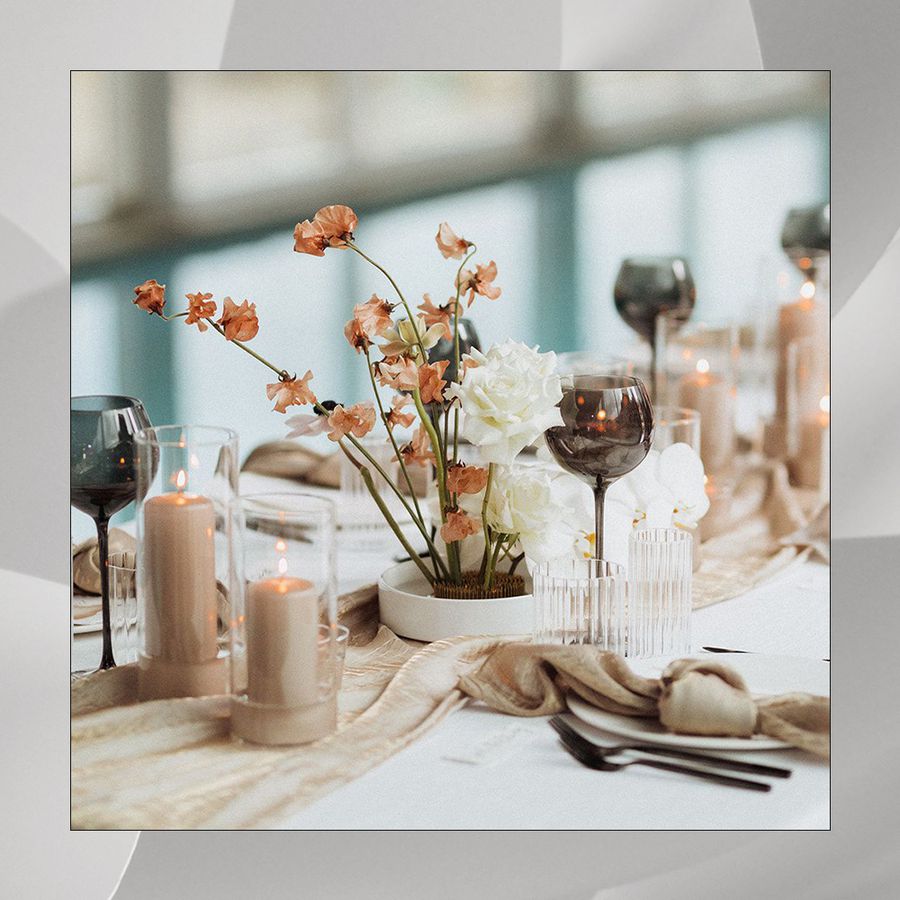 Modern wedding table decor with black glassware, candles, a runner, and florals