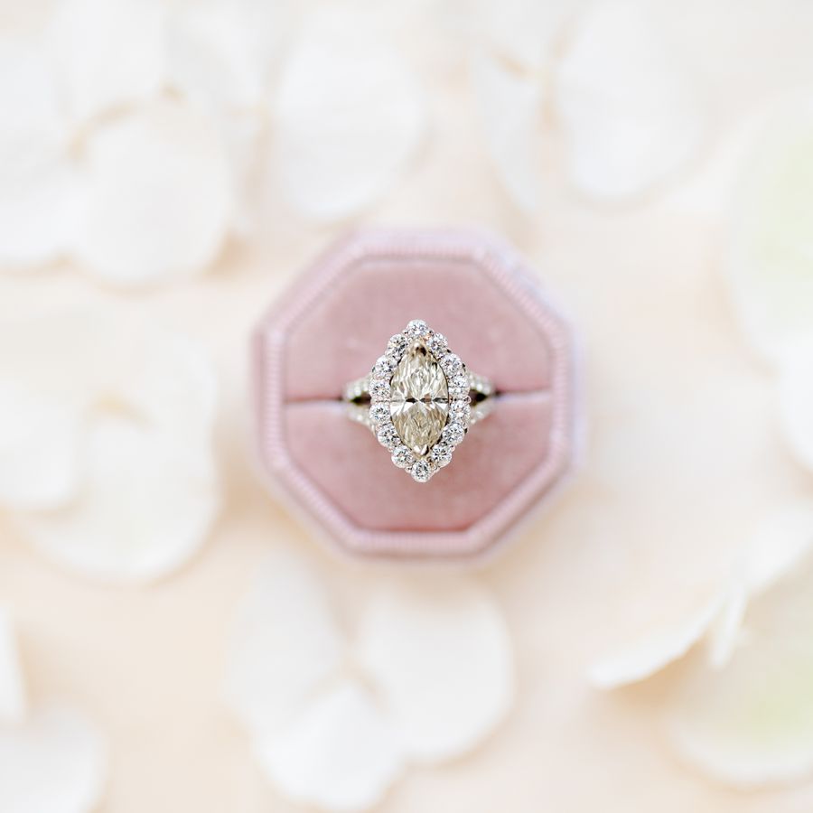 marquise-cut halo engagement ring in a pink ring box