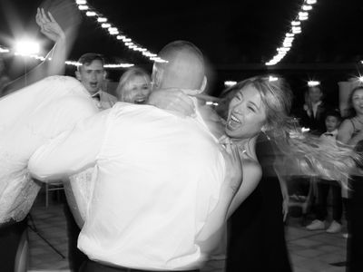 Couple Twirling on the Dance Floor at Wedding Reception Laughing