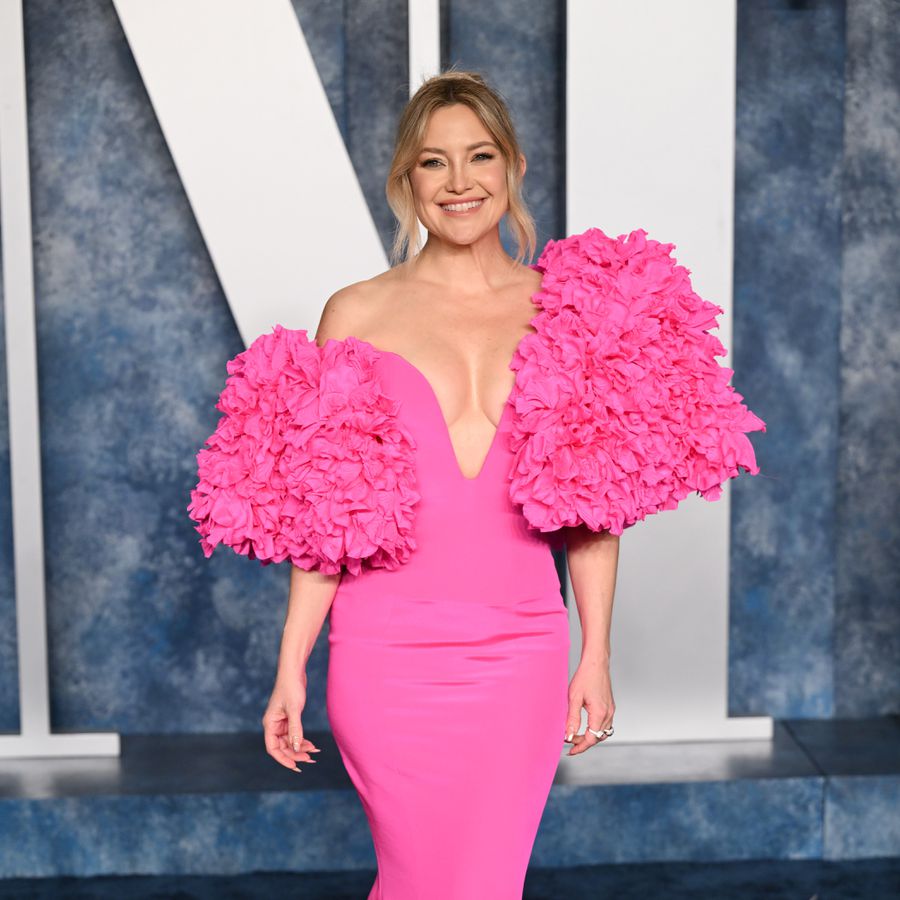 Kate Hudson smiling in a frilly pink dress at the Vanity Fair Oscar Party