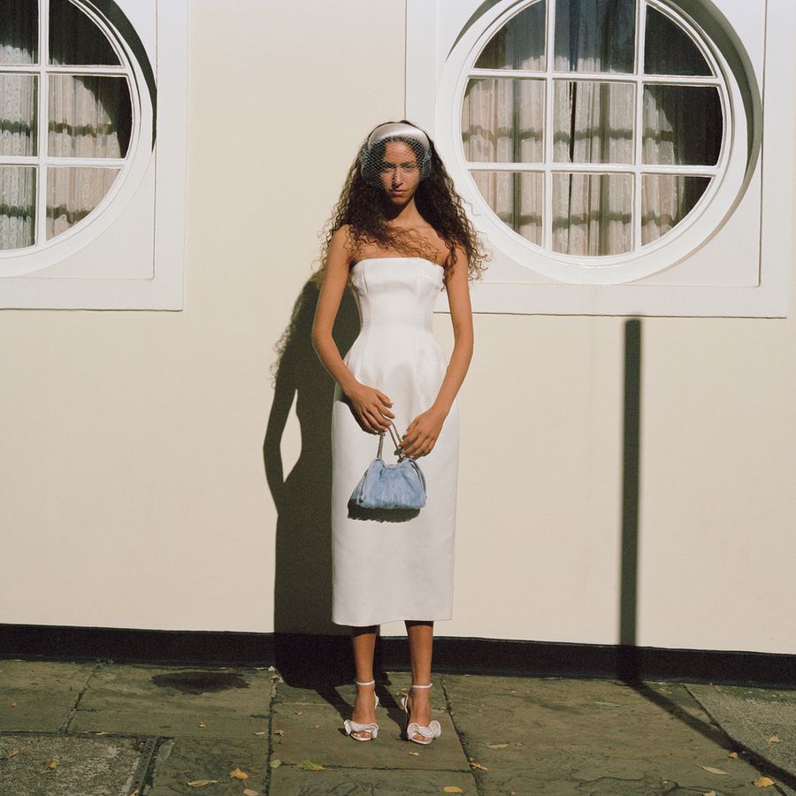 bride wearing strapless white midi dress, blue handbag, Loeffler Randall heels