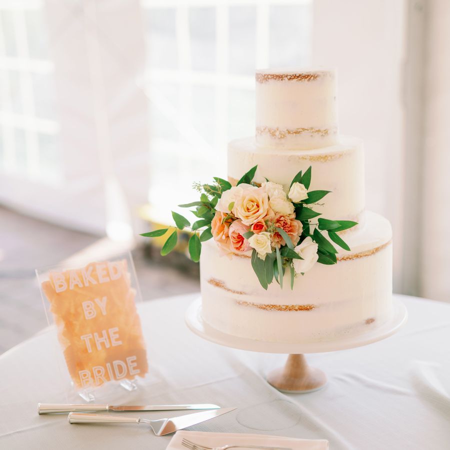 A homemade three-tier semi-naked cake with flowers