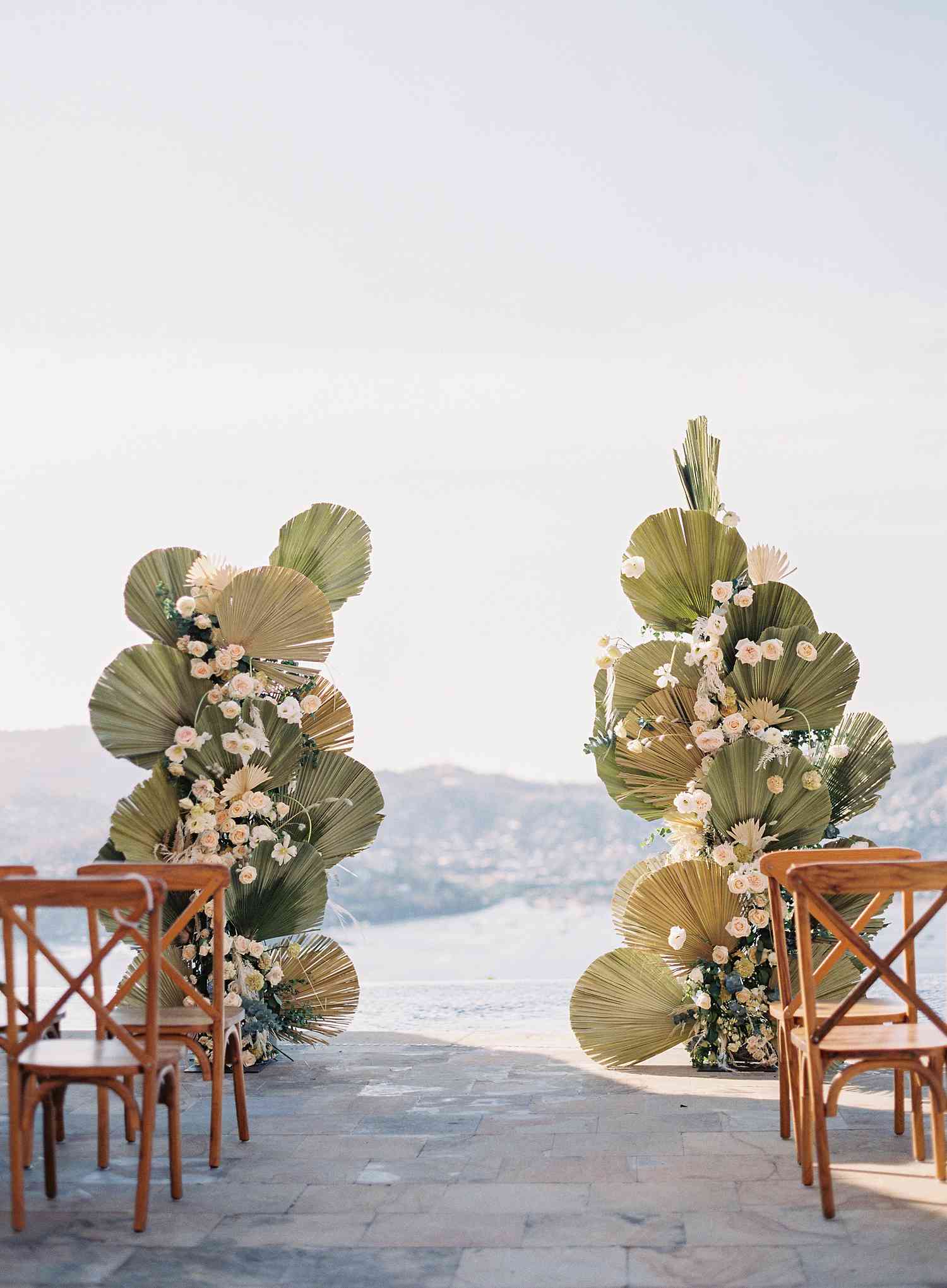A wedding aisle using green plant fans.