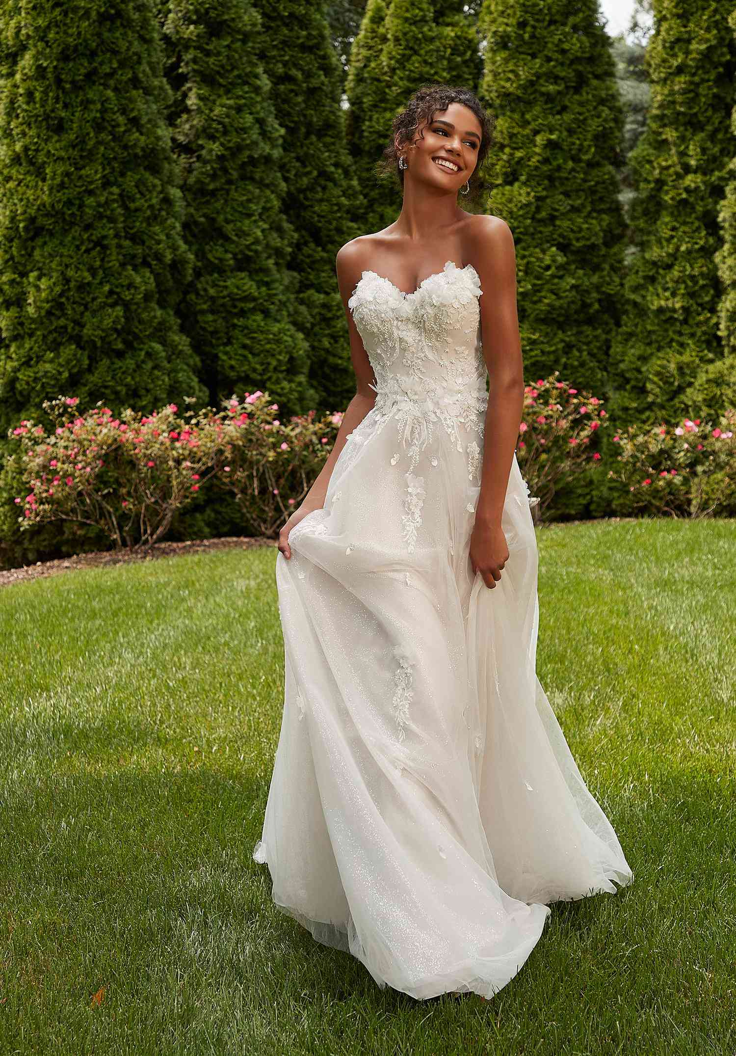 Model wearing a strapless tulle and floral wedding dress