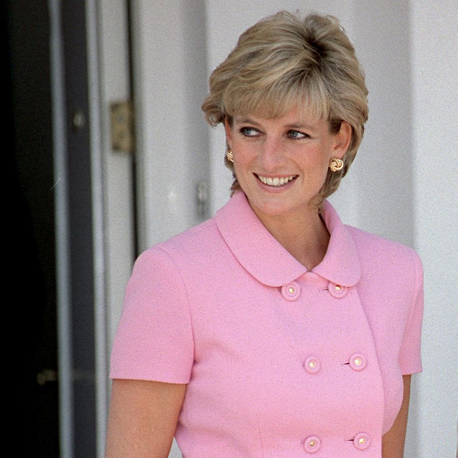 Princess Diana smiling and looking off to eat side in a pink suit