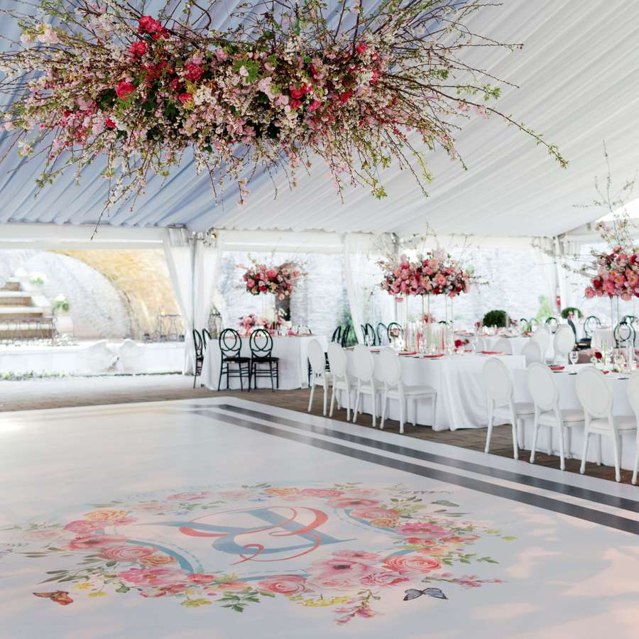 custom dance floor with florals and monogram with floral installation overhead