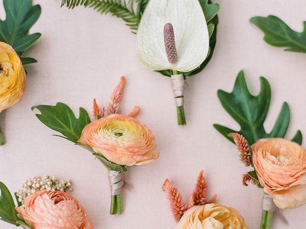 Array of tropical-inspired wedding party boutonnieres