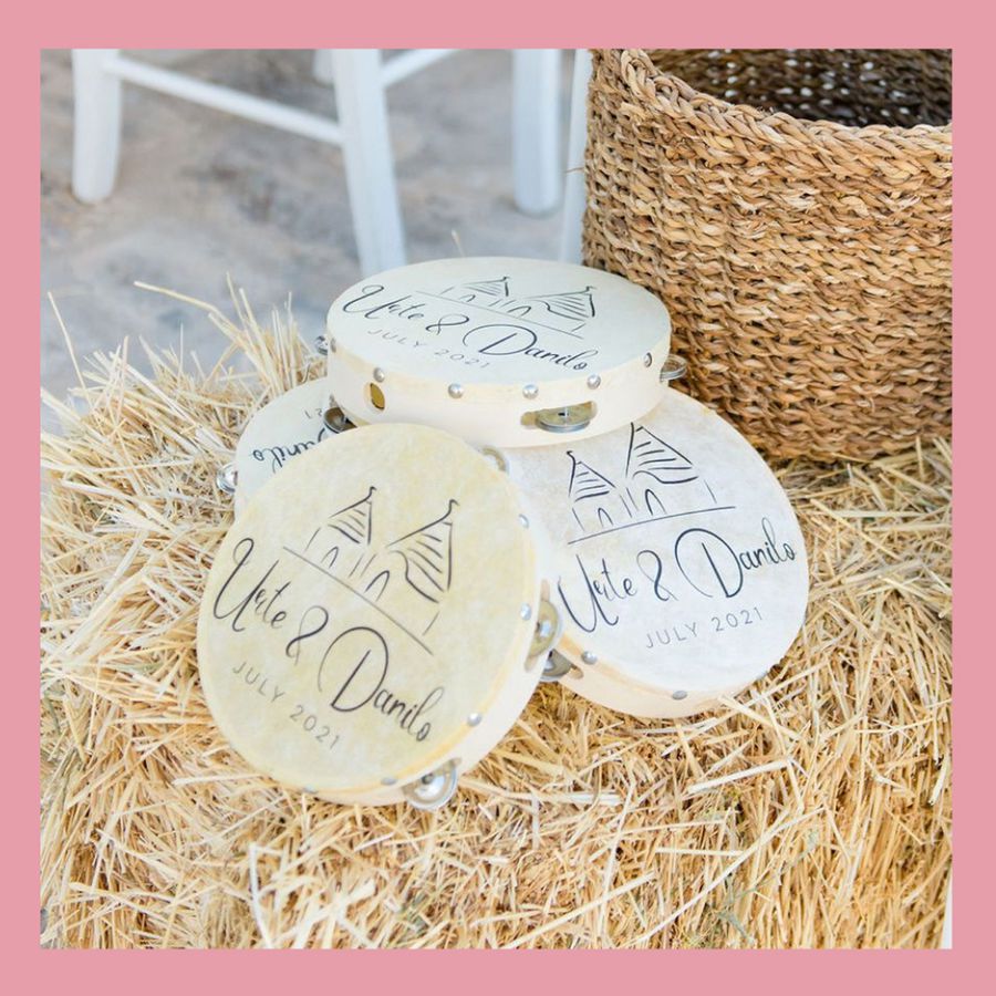 Customized wedding favor tambourines on a straw bale