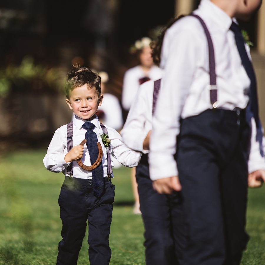 Page boys in suspenders holding horseshoes at Irish Wedding