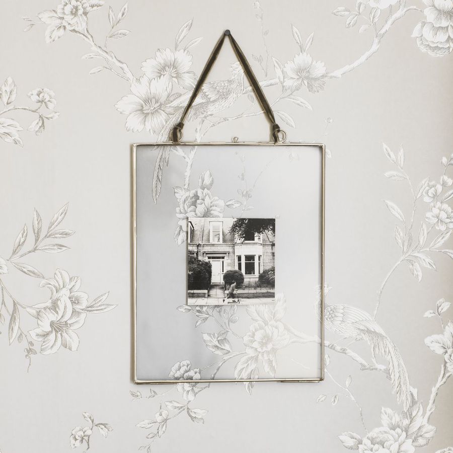 Black and white photo of a house in a floating picture frame hanging on a wall