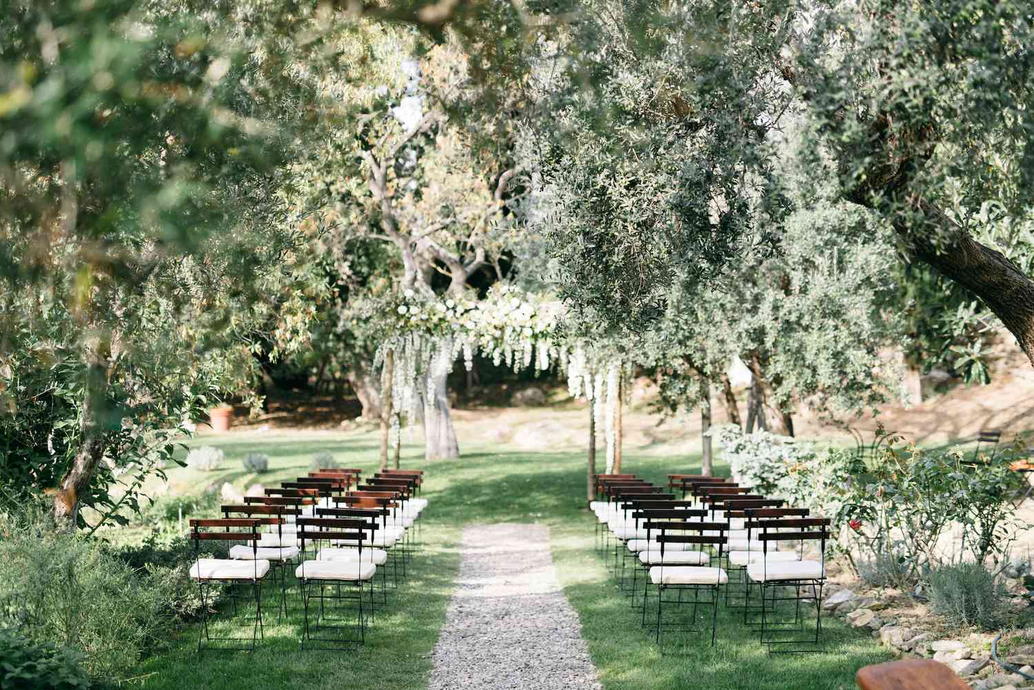 Garden wedding with a gravel aisle and greenery decor