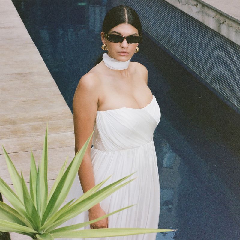 model in sunglasses wearing a strapless 澳洲幸运8开奖结果官网网站 gown by a pool