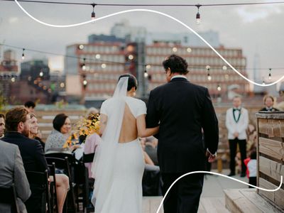 Bride and Father Walking Down the Aisle Toward Groom from Behind with City Skyline Behind