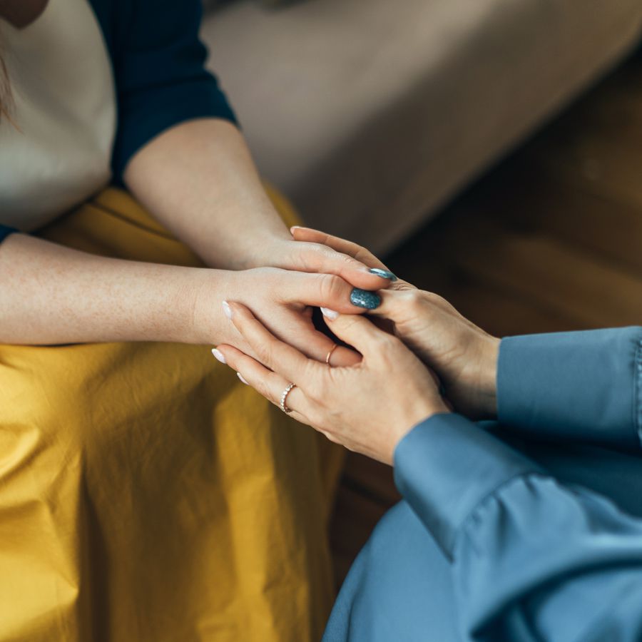 Two Women Holding Hands Sitting on Couches