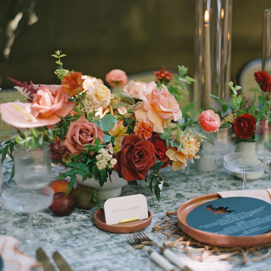 red and dusty rose wedding centerpiece with roses, ranunculus, and anthurium