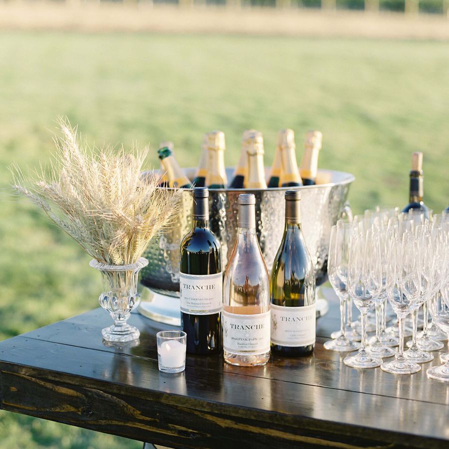 Trio of Wines on Outdoor Wooden Wedding Bar with Champagne Bottles on Ice Behind