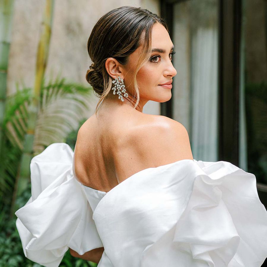 bridal portrait of influencer Rachel Love wearing an off-the-shoulder wedding dress and diamond leaf-motif earrings