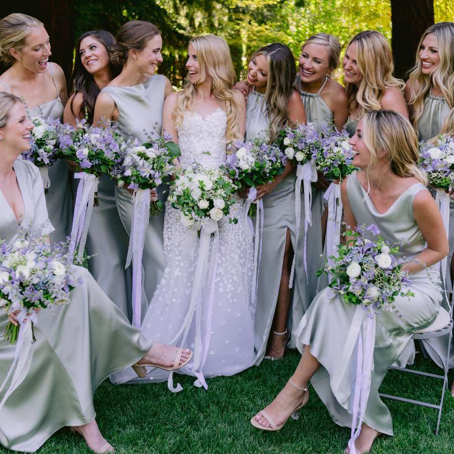 bride and bridesmaids holding purple and white bouquets