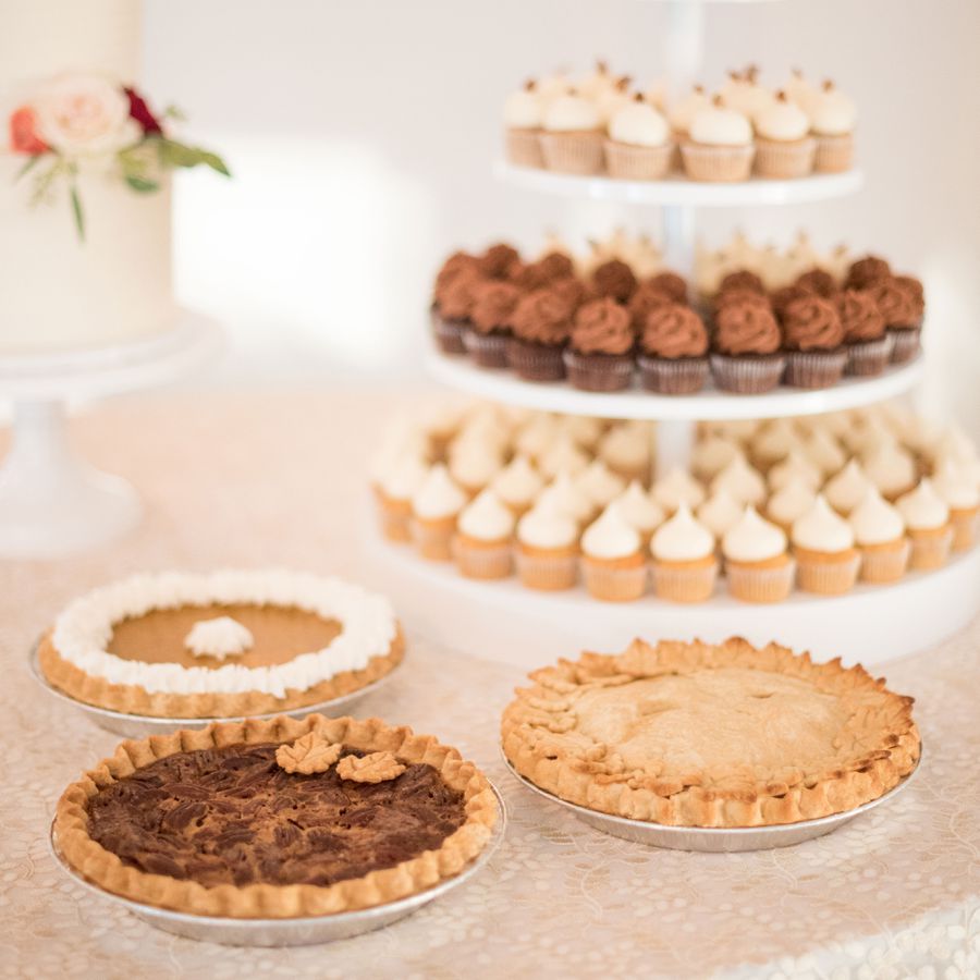 Dessert bar with pumpkin pie, pecan pie, and apple pie with a mini cupcake tower and white wedding cake