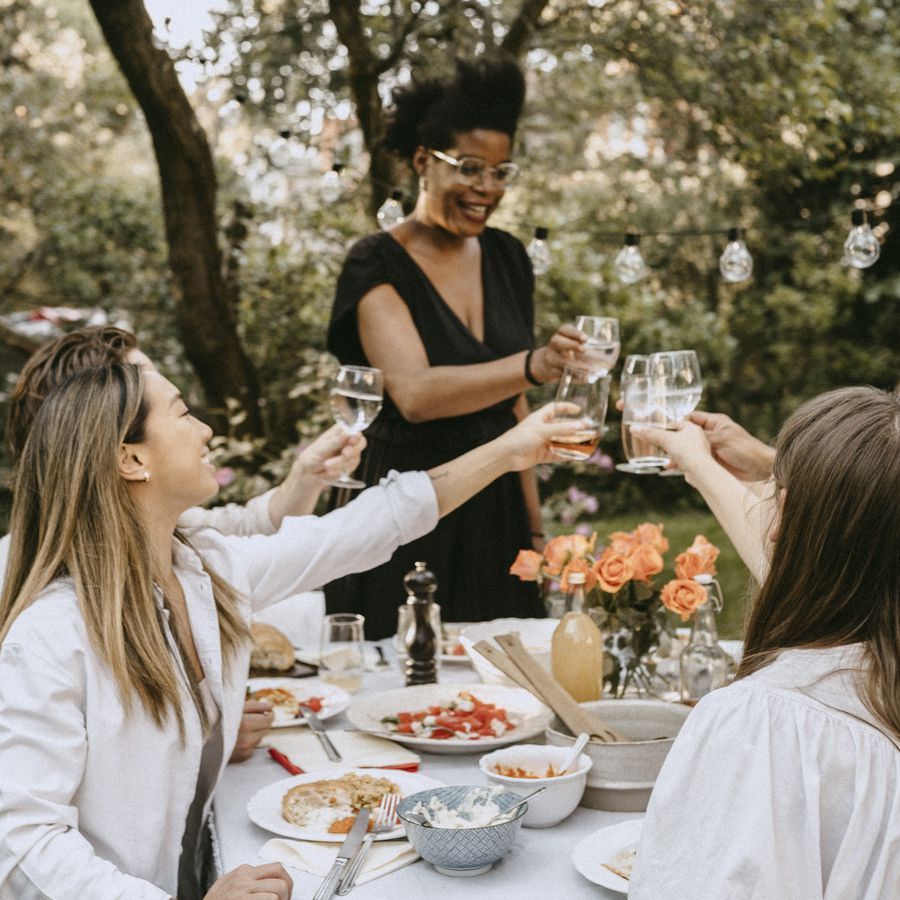 Group of women toasting at outdoor table decorated for party