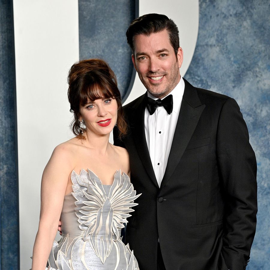 Zooey Deschanel and Jonathan Scott posing on the red carpet at the Vanity Fair Oscar Party
