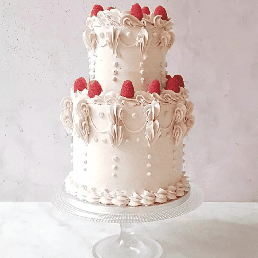 Two-tier white lambeth cake with raspberry accent